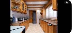 Una cocina con gabinetes de madera y encimera. en Torrent Veda Chalet, en Torrent