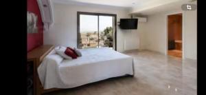 Un dormitorio con una cama blanca y una ventana grande. en Torrent Veda Chalet, en Torrent 13 fotos más