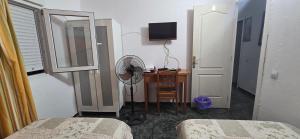 a room with a bedroom with a desk and a fan at Rooms Plaza hierro in San Bartolomé de Tirajana