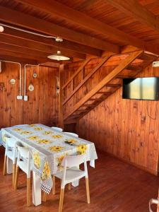 Un comedor con una mesa con sillas y un televisor. en Los olivillos, en Balneario Pehuén-Có