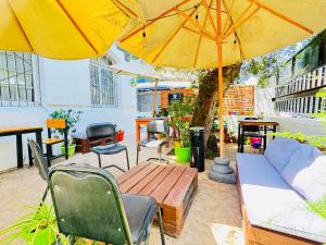 a patio with a table and chairs and a yellow umbrella at Hotel Casa Lyon in Santiago