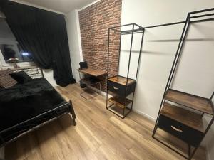 a bedroom with a black bed and a brick wall at Gästezimmer Tokyo im Werkmotel in Winhöring