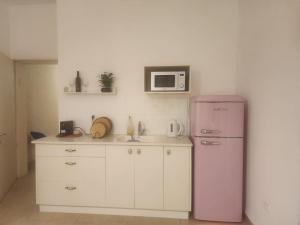 a kitchen with a pink refrigerator and a microwave at חדרי אירוח ליאורה in Qiryat Shemona