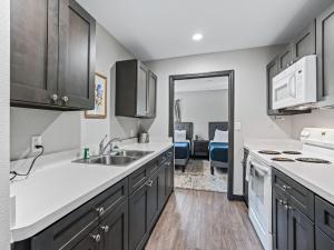 オカラにあるBaymont by Wyndham Ocala Suitesのシンクとコンロのあるキッチン トップオーブン +54枚の写真