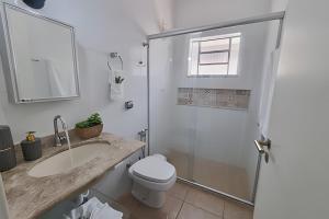 a bathroom with a shower and a toilet and a sink at Costa Family-Little house in the center in Santa Rita do Sapucaí +35 photos