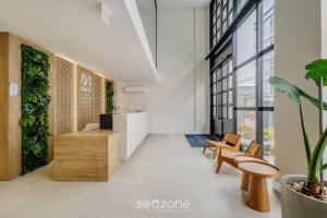 a lobby of a building with benches and plants at Aptos em prédio com piscina a 220m da Praia em Bombinhas - SFRs in Bombinhas +2 photos
