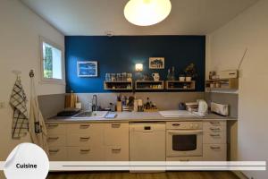 eine Küche mit einem Waschbecken und einer blauen Wand in der Unterkunft La Maison Brévinoise, Pines in Saint-Brévin-lʼOcéan