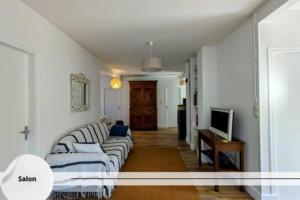 ein Wohnzimmer mit Sofa und Fernseher in der Unterkunft La Maison Brévinoise, Pines in Saint-Brévin-lʼOcéan