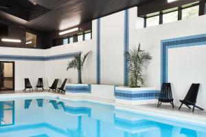 a swimming pool with chairs next to a building at Bluebird Cady Hill Lodge in Stowe