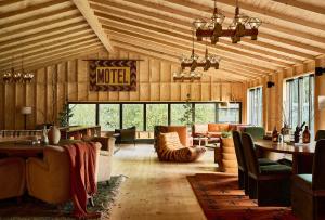 a living room with wood paneling and a large room with tables and chairs at Bluebird Cady Hill Lodge in Stowe