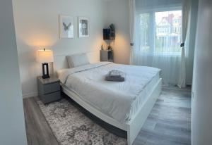 a bedroom with a bed with a lamp and a window at Bentley Commons Fallsview - Luxury 4 Bedroom 4 Bath Townhouse in Niagara Falls