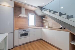 eine Küche mit weißen Schränken und einer Treppe in der Unterkunft Luxury Beach Terrace Loft in Las Palmas de Gran Canaria