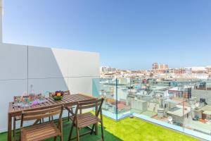 einen Balkon mit einem Tisch und Stühlen sowie Stadtblick in der Unterkunft Luxury Beach Terrace Loft in Las Palmas de Gran Canaria
