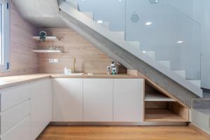 eine Küche unter der Treppe mit weißen Schränken in der Unterkunft Luxury Beach Terrace Loft in Las Palmas de Gran Canaria + 42 Fotos