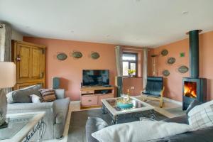 a living room with a couch and a fireplace at Owl Lodge in Ufford