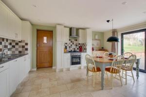 a kitchen with a table and chairs and a dining room at Owl Lodge in Ufford