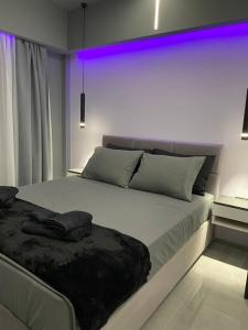 a bedroom with a large bed with purple lights on it at Crystal Grey Elite Appartment 3 in Serres