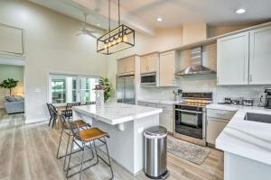 a kitchen with white cabinets and a kitchen island with chairs at Luxury Scottsdale Vacation Rental with Patio! in Scottsdale
