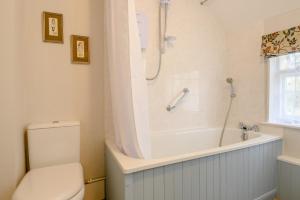 ein Badezimmer mit Badewanne, Toilette und Dusche in der Unterkunft Riverside Cottage in Snape