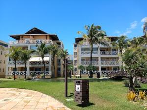 a large building with palm trees in front of it at Portamaris Resort - Beach Park - Pé na Areia 3Q in Aquiraz