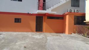 un edificio naranja y blanco con ventanas negras en The perfect place in Samana, en Santa Bárbara de Samaná