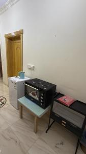 a kitchen with a toaster oven on a table at Cosy Apartment in Madinah in AR Rummanah