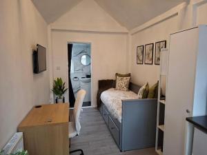 Un dormitorio pequeño con una cama y un escritorio. en Private Fully Furnished Studio Flat!, en Luton