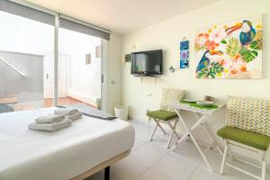 a bedroom with a bed and a desk and a tv at Sun Suite Canteras I in Las Palmas de Gran Canaria