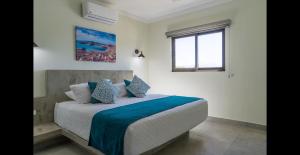 a bedroom with a bed with blue sheets and a window at Santa Cruz Suite #23 in La Paz