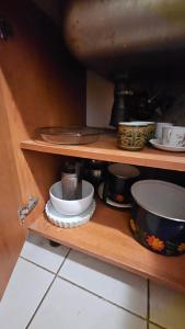 a shelf with bowls and other dishes on it at Departamento SAN LUIS CENTRO CON COCHERA in San Luis +4 photos