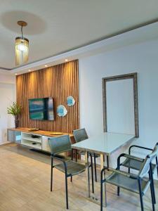 a dining room with a glass table and chairs at Elegance Residences Cumbuco in Caucaia