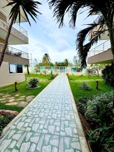 a stone walkway in front of a building at Elegance Residences Cumbuco in Caucaia