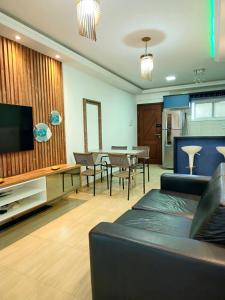 a living room with a couch and a television at Elegance Residences Cumbuco in Caucaia +7 photos