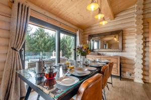 a dining room with a table and chairs and a large window at Woodland Retreat Cabin in Kippford
