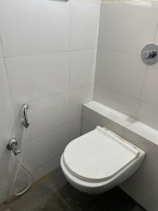 a white bathroom with a toilet and a shower at Silver Homes In Nagala Park Stay On 7th Floor in Kolhapur +15 photos