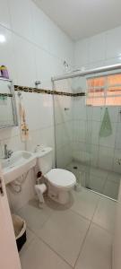 a white bathroom with a toilet and a sink at Casa privativa e aconchegante com área de lazer in São Sebastião do Paraíso