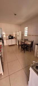 a kitchen with a table and two chairs and a table and a tableasteryastery at Casa privativa e aconchegante com área de lazer in São Sebastião do Paraíso