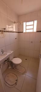 a white bathroom with a toilet and a sink at Casa privativa e aconchegante com área de lazer in São Sebastião do Paraíso +6 photos