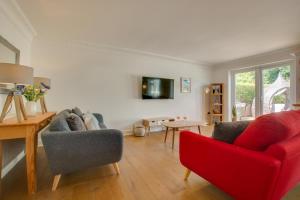 sala de estar con sofá rojo y silla roja en Denbury House, en Bodham