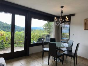 a dining room with a table and chairs and windows at Beautiful apartment near Luzern, view to Rigi,Pilatus Mountain in Luzern