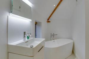 a white bathroom with a sink and a mirror at The Granary in Banningham +40 photos