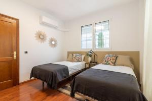 Un dormitorio con dos camas y una ventana en Villa Veneguera + Seaview + Pool + Garden, en Maspalomas