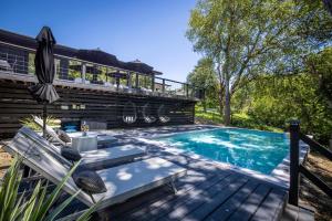 a swimming pool with a deck and a house at Lake Access Pool Loungers Fire Pit Grill in McQueeney