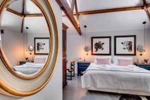 2 fotos de un dormitorio con espejo en The Cattle Shed, en Wighton