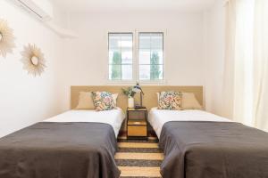 dwa łóżka ustawione obok siebie w pokoju w obiekcie Villa Veneguera + Seaview + Pool + Garden w mieście San Bartolomé +44 zdjęcia