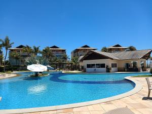 a swimming pool in front of a resort at Apto 3 quartos Portamaris Pé na Areia Porto das Dunas in Aquiraz