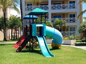 a slide in a park in front of a building at Apto 3 quartos Portamaris Pé na Areia Porto das Dunas in Aquiraz