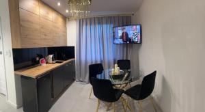 a kitchen with a glass table and a television on the wall at Badia in Strzelce Opolskie