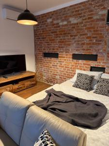 a living room with a couch and a brick wall at CosyCentrumFlat in Slezská Ostrava +4 photos
