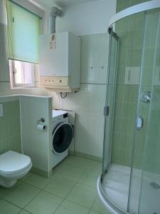 a bathroom with a shower and a washing machine at CosyCentrumFlat in Slezská Ostrava